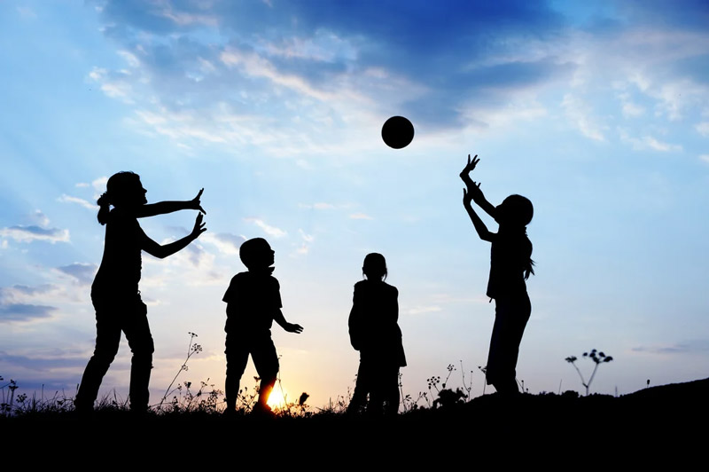 Happy children playing hand ball at sunset time